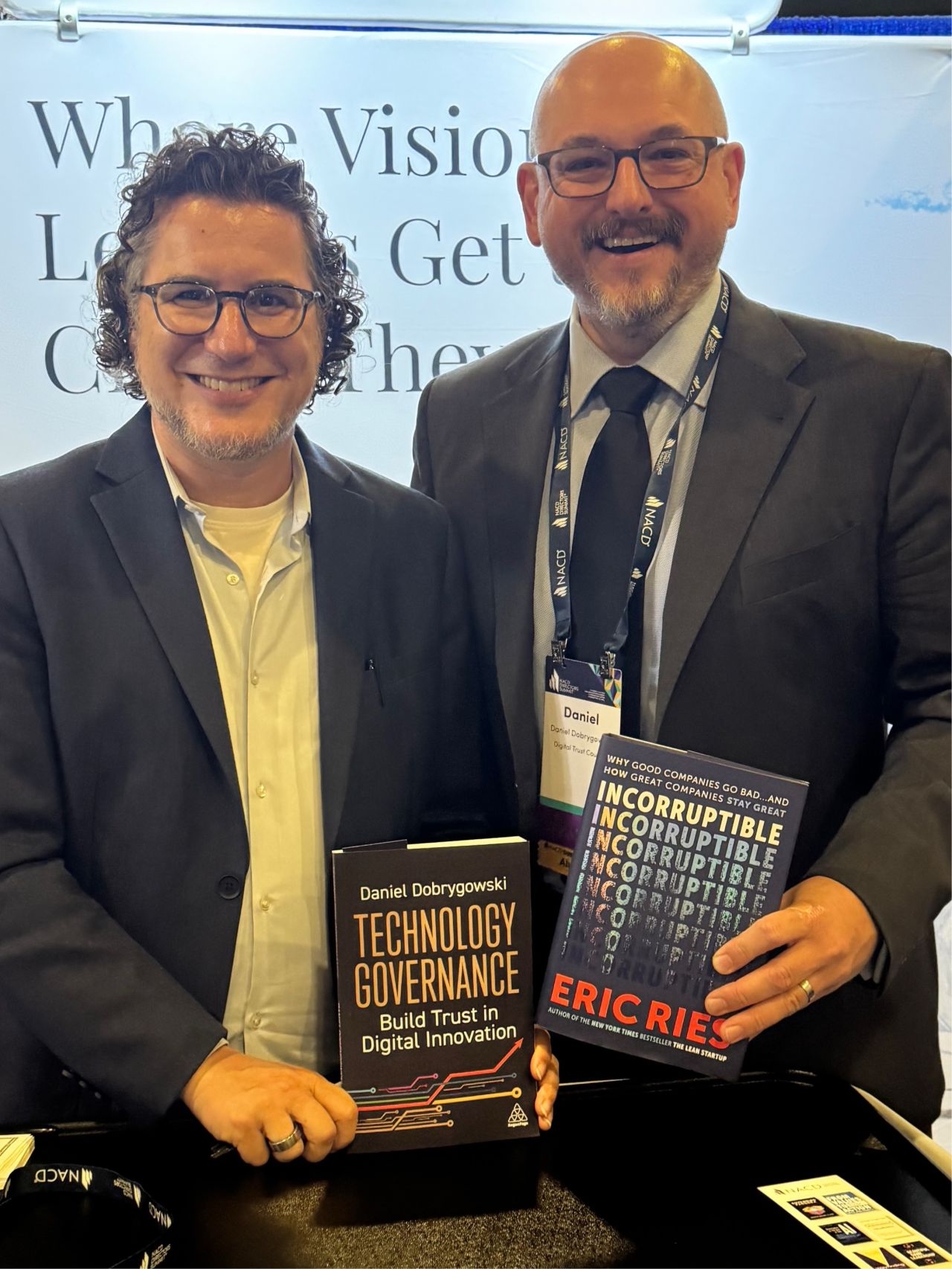 Daniel Dobrygowski (WEF · author, Technology Governance) swaps signed books with Eric at the Summit — 'Good governance is having a moment!'